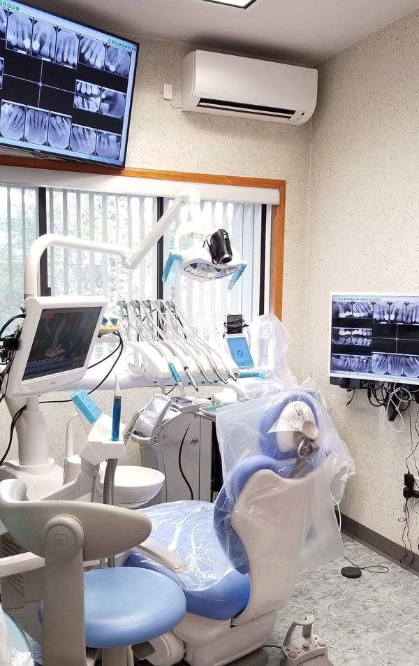 dental exam room with images of dental x-rays on tv screen
