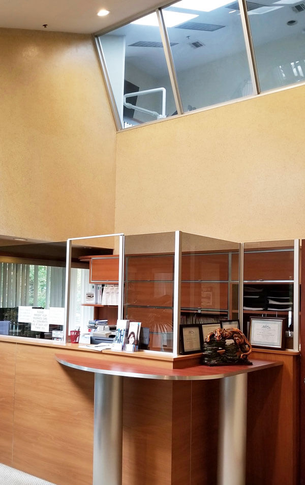 dental reception desk with exam room with windows above it