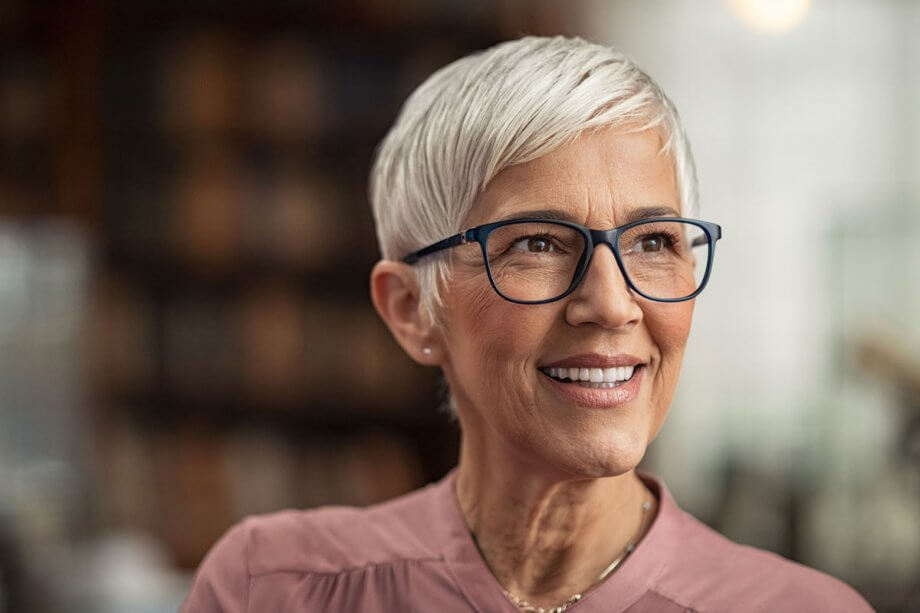 headshot of older woman with short hair and dark-framed glasses