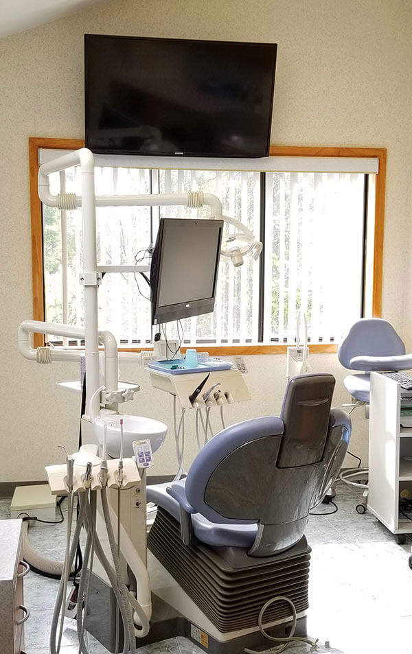dental exam room with flat screen tv on wall