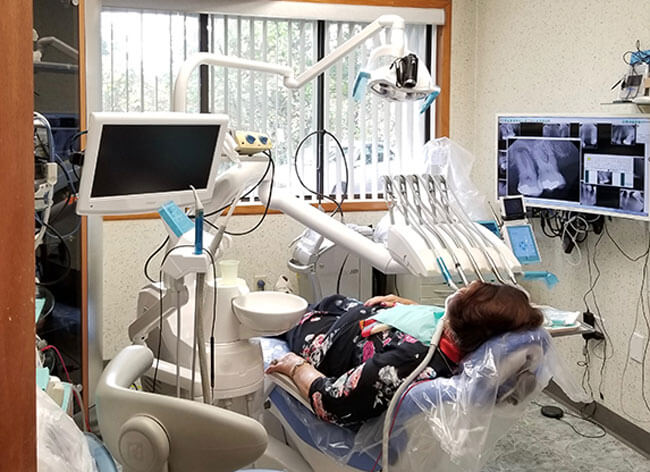 dental exam room with female patient in exam chair